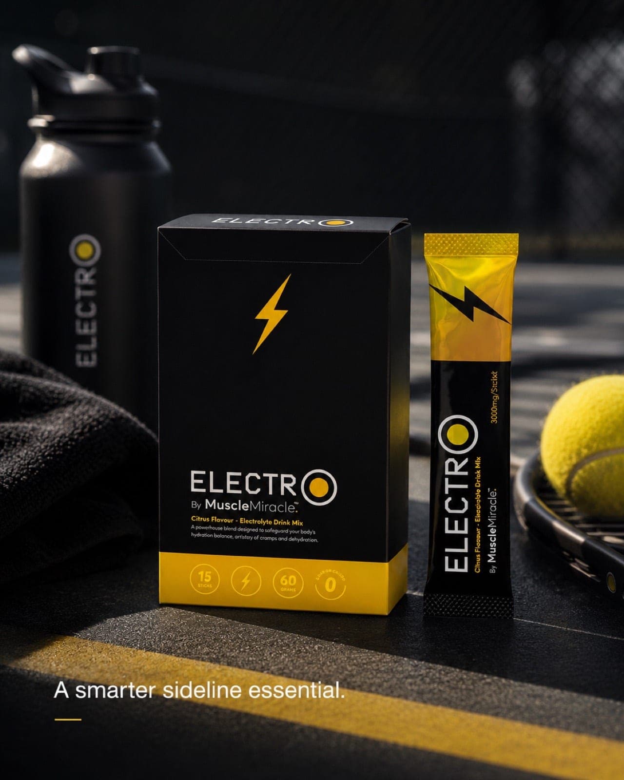Muscle Miracle Electrolytes Citrus pack and sachet courtside with a racket, ball and water bottle